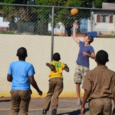 A Projects Abroad volunteer gains sports coaching work experience teaching children in Jamaica Students learn the basics of basketball during volunteer sports coaching in schools in Jamaica